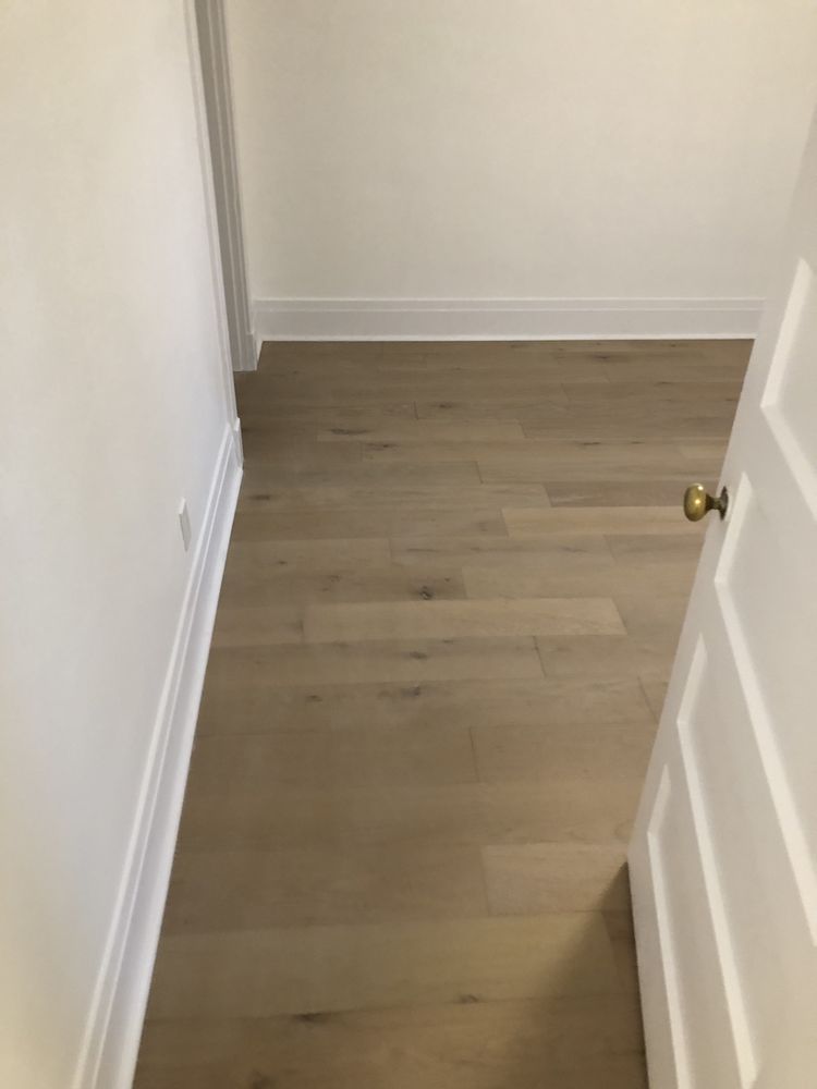 Hallway with new plank flooring and white baseboards